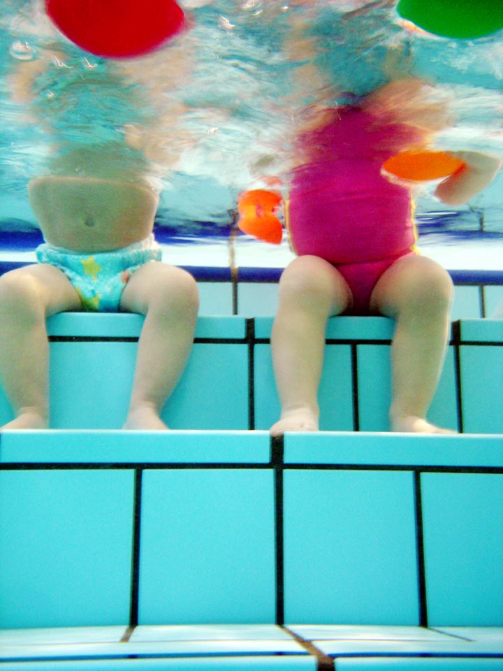 Ds bebés jugando en la piscina.